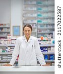 Small photo of Providing prescriptions and a smile. Portrait of an attractive young pharmacist standing at the prescription counter.