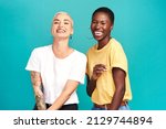 Small photo of Life is beautiful with your bestie by your side. Studio shot of two happy young women posing together against a turquoise background.