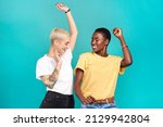 Small photo of Grab your girl and get grooving. Studio shot of two young women dancing together against a turquoise background.