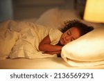 Small photo of I like moms bed the best. A cute little girl fast asleep in a double bed.