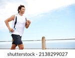 Small photo of Building up his stamina. Cropped shot of a handsome young man running along the promenade.