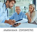 Small photo of Ive got the test results right here. Shot of a doctor discussing some paperwork with a senior patient and his daughter in a clinic.