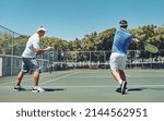 Small photo of Work on that swing. Full length shot of a handsome mature sportsman coaching a fellow team-mate during a tennis training session.