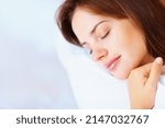 Small photo of Closeup of a pretty female fast asleep in bed. Closeup portrait of a cute young female fast asleep in bed.