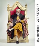 I took the throne peacefully. Studio shot of a richly garbed king sitting on a throne.