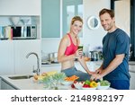 Take your health into your own hands. Portrait of a couple preparing a nutritious meal together at home.