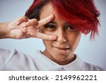 Small photo of Be unafraid to be yourself. Studio shot of a beautiful young woman showing the peace gesture over her eye.
