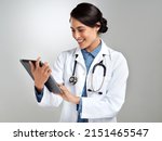 Small photo of Get connected for medical advice on demand. Studio shot of a young doctor using a digital tablet against a grey background.