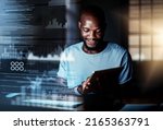 Deciphering new data. Shot of a programmer using a digital tablet while working on a computer code at night.