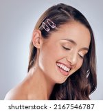 Small photo of You never outgrow fun hair clips. Shot of an attractive young woman standing alone in the studio and posing.