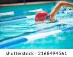 Working on her stroke. Shot of a professional female swimmer freestyle swimming in her lane.