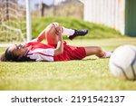 Small photo of Injured, pain or injury of a female soccer player lying on a field holding her knee during a match. Hurt woman footballer with a painful leg on the ground in agony having a bad day on the pitch