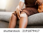 Small photo of Child with plaster or bandaid, injured and hurt by accident while playing a sport, exercise or outside closeup. Kid with a medical bandage after help on wound, injury or scratch on skin, knee or leg