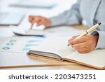 Finance, writing and notebook with employee with accounting, planning and documents of chart analytics. Accounting, budget and investment with business woman working with calculator, audit and growth