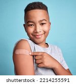 Small photo of .Child black, band aid and happy kid with vaccine, in blue studio background and relax with smile or joyful. Portrait, boy and adhesive bandage with arm bruise, confident and vaccination for health.