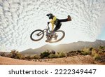 Dessert, mountain bike and high jump trick for crazy fun competitive race, extreme sports performance and stunt freedom. Dirt biker flying in the air, adrenaline sport risk and awesome adventure ride