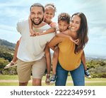 Small photo of Happy family, mother and father with children on back in a nature park for bonding and relaxing in summer. Smile, mom an dad love enjoying quality time with siblings or kids outdoors for fresh air