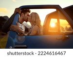 Small photo of Stopping for a smooch. Shot of an affectionate young couple on a roadtrip.