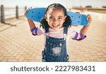 Small photo of Child, skateboard and excited for fun activity outdoor on promenade with smile, happiness and energy on summer vacation. Portrait of black girl with safety gear for elbow for skating or skateboarding
