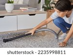 Small photo of Woman, cleaning and vacuum machine for carpet in house, home or hotel living room in hygiene maintenance or housekeeping. Maid, cleaner service or worker with suction on floor rug for spring cleaning