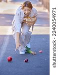 Small photo of Drop, accident and woman with groceries in the street, clumsy and trip while walking with shopping bag in the city of Japan. Falling, tripping and wow of an Asian girl with grocery food in the road