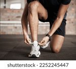 Small photo of Fitness, man and tying shoe lace getting ready for running exercise, workout or training at gym. Sporty male, person or guy shoes in preparation for sport run, cardio or warm up on floor at gymnasium