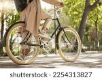 Bicycle, closeup and feet of casual cyclist travel on a bike in a park outdoors in nature for a ride or commuting. Exercise, wellness and lifestyle student cycling as sustainable transport