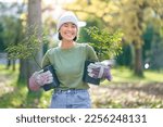 Small photo of Woman portrait, plant and gardening in a park with trees in nature environment, agriculture or garden. Happy volunteer planting for growth, ecology and sustainability for community on Earth day