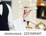 Fine dining, food and waiter serving at a restaurant for a luxury valentines day or anniversary meal. Formal, hospitality service and server with a plate or dish for a fancy special dinner date.