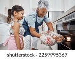 Small photo of Muffins, learning and grandmother with girl cooking and taking out cupcakes from oven. Education, kitchen and happy grandma teaching child how to bake, bonding and enjoying quality time together.