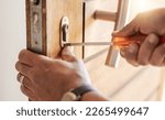 Small photo of Locksmith hands, maintenance and handyman with tools, home renovation and fixing, change door locks and closeup. Construction, building industry and trade with manual labour, vocation and employee