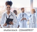 Black woman, doctor portrait and tablet with medical team in hospital ready for healthcare work. Wellness, health and medic employee in a clinic feeling happiness and success with blurred background
