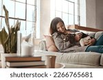 Small photo of Woman relax on couch with puppy, happy and content at home with pet, happiness together with peace in living room. .Female cuddle dog, love for animals with smile and care, stress relief and comfort