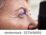 Small photo of Eye exam, vision or laser test for an old woman with a machine at optometry consultation for retina problem. Senior, patient or client with medical health insurance checking eyesight at optician