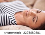 Small photo of Fast asleep with sweet dreams. an attractive young sleeping on her sofa at home.