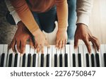 Small photo of Hands, parent and kid learning piano as development of skills together and bonding while making music in a home. Closeup, musical and child playing a song on an instrument and father teaching