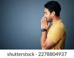 Small photo of Pray, faith and mockup with a man in studio on a gray background asking god for a miracle or help. Trust, religion and spiritual with a handsome young male christian praying to jesus in belief