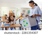 Small photo of Teacher, recycle bin and girl in classroom throwing trash for cleaning, climate change or eco friendly in school. Recycling plastic, learning and education with happy student or kid in kindergarten.
