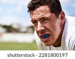 Small photo of Collision sport requires a bit of extra protection. a young man wearing a gum guard while playing a game of rugby.