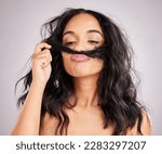 Small photo of Beauty, salon and woman smell hair, aesthetic and cosmetics on a grey studio background. Female, moustache and lady with facial expression, silly and goofy with treatment, smelling clean and wellness