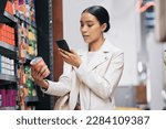 Supermarket, customer and price check on smartphone to compare product cost on ecommerce app. Grocery shop inflation and increase in spending money with essential lifestyle consumables.