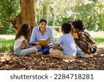 Small photo of Teacher reading, tree or children with book for learning development, storytelling or growth in park. Smile, youth or happy educator with stories for education at a kids kindergarten school in nature