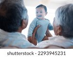 Small photo of Babys have the gift of making everyone silly. Shot of grandparents bonding with their grandchild on a sofa at home.