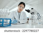 Small photo of Proving my hypothesis correct. a young woman making notes in her lab.