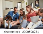 Small photo of Technology, streaming and a happy family on the sofa for internet, social media and communication. Smile, bonding and a mother, father and children with a tablet and phone for online games at home