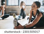 Fitness, gym and women stretching, exercise and workout goal for wellness, balance and stress relief. Female people, girls and athletes on the floor, stretch legs and smile with training and health