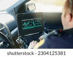 Small photo of Database, laptop and a police officer in a car for security, urban law and safety data while working. Screen, programming and male protection professional with a computer to hack system in transport