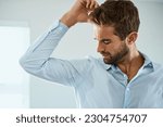 Shirt, stress with man smelling armpit sweat stain and indoors at his home. Hygiene or hyperhidrosis, deodorant protection for sweaty mark on clothing and young male person sweating with wet spot