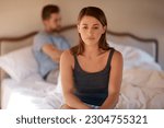 Small photo of Sad, upset and couple in an argument in their bedroom for divorce or breakup in a modern house. Toxic, mad and face of a woman fighting and in conflict with her boyfriend in bed in their home.