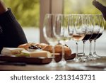 Wine tasting, cheese platter and winery restaurant with alcohol and glass for customer. Waiter, drink and sommelier with bottle for wines and food pairing in a fine dining and luxury experience